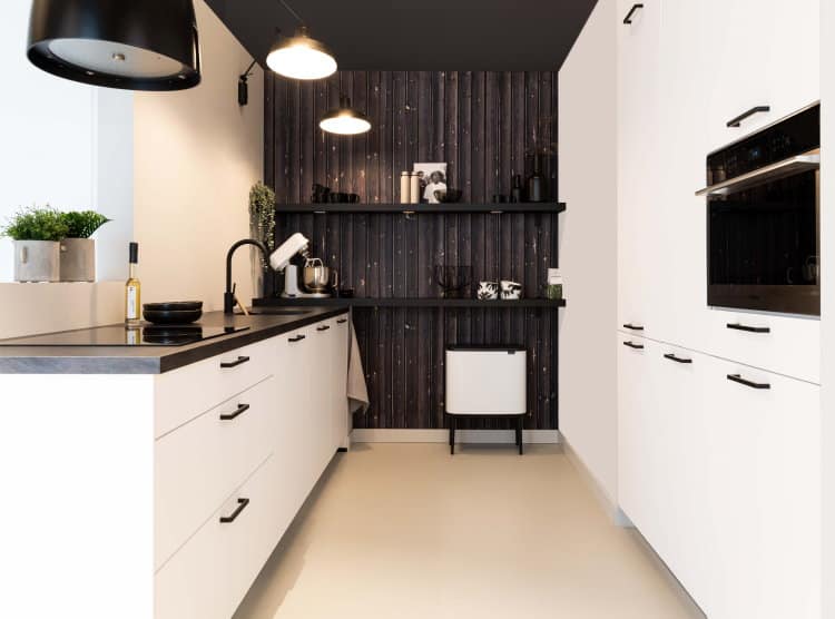 Witte industrieel moderne keuken met betonlook aanrechtblad, ronde design afzuigkap en zwarte latjes behang - KeukenCoach keuken New York