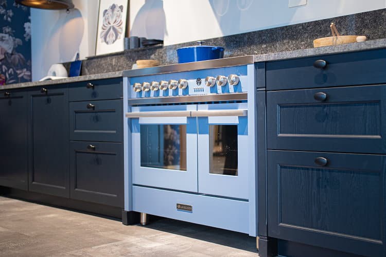 Blauw Lancellotti inductie fornuis 90 cm 2 ovens RVS in donkerblauwe landelijke keuken