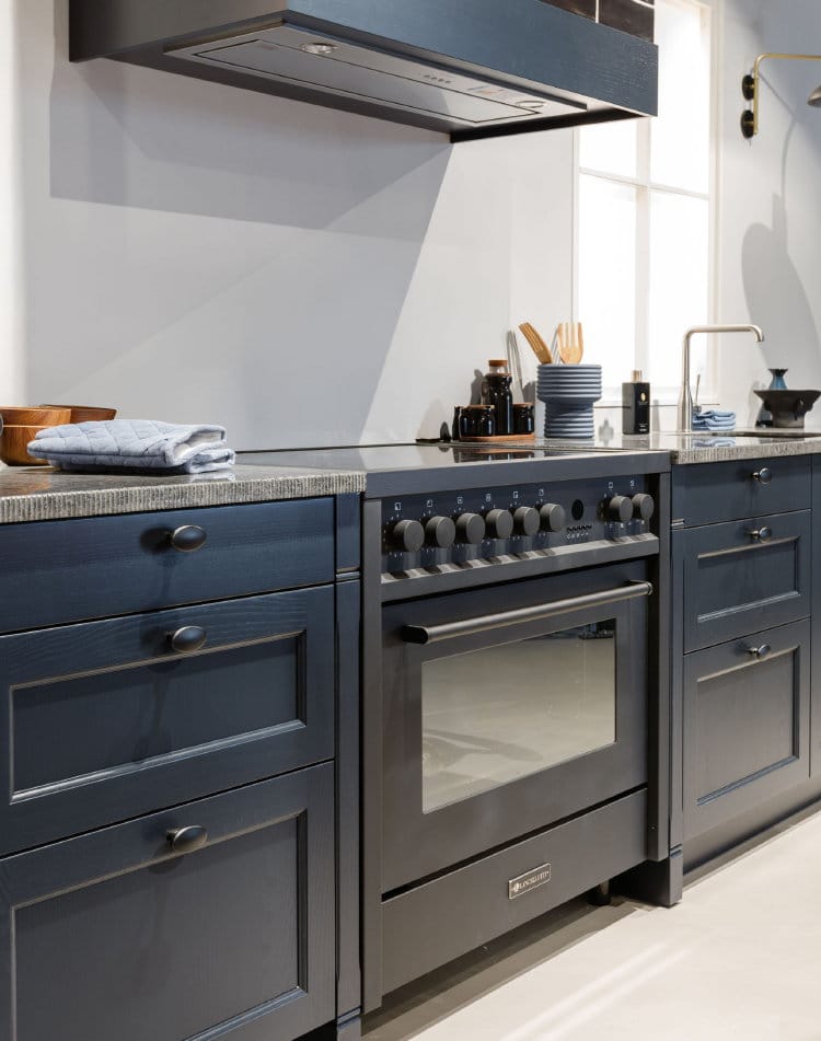 Zwarte Lancellotti inductiefornuis 90 cm Adagio met 1 oven en 5 kookzones in donkerblauwe landelijke keuken