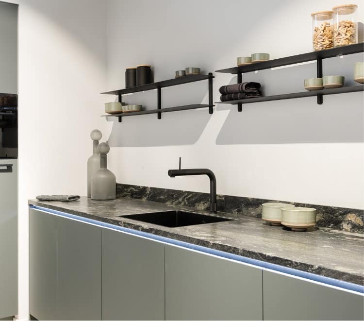 Keukentrends 2026: groene moderne keuken met granieten aanrechtblad zwart wit gemarmerd Titanium Papato, Quooker Front met zwarte rimless spoelbak en Gejst wandplanken Nivo C