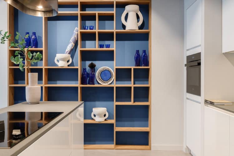 Witte moderne keuken met houten kast met blauwe open vakken en wit blauwe accessoires