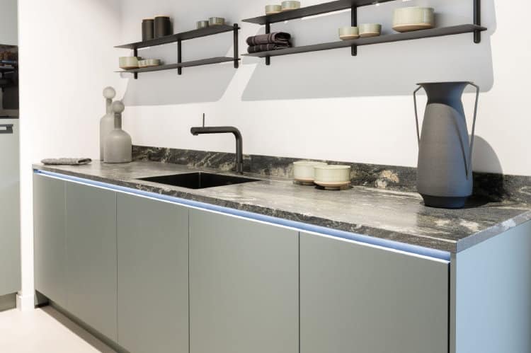 Keukentrends 2026: groene moderne keuken met granieten aanrechtblad zwart wit gemarmerd Titanium Papato, Quooker Front met zwarte rimless spoelbak en Gejst wandplanken Nivo C